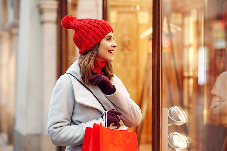 Femme faisant du shopping devant une vitrine